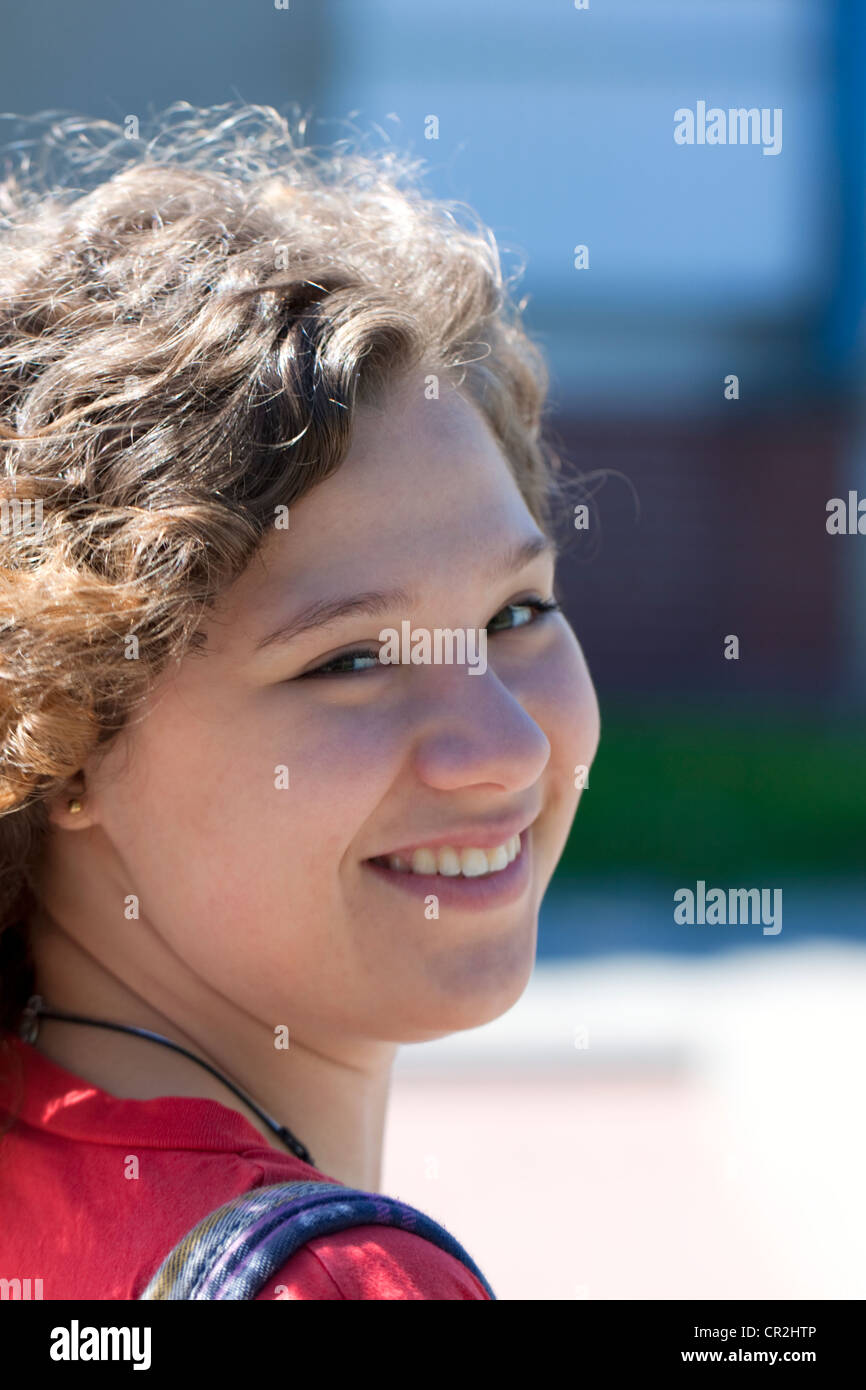 Teenage girl looking back, smiling Stock Photo