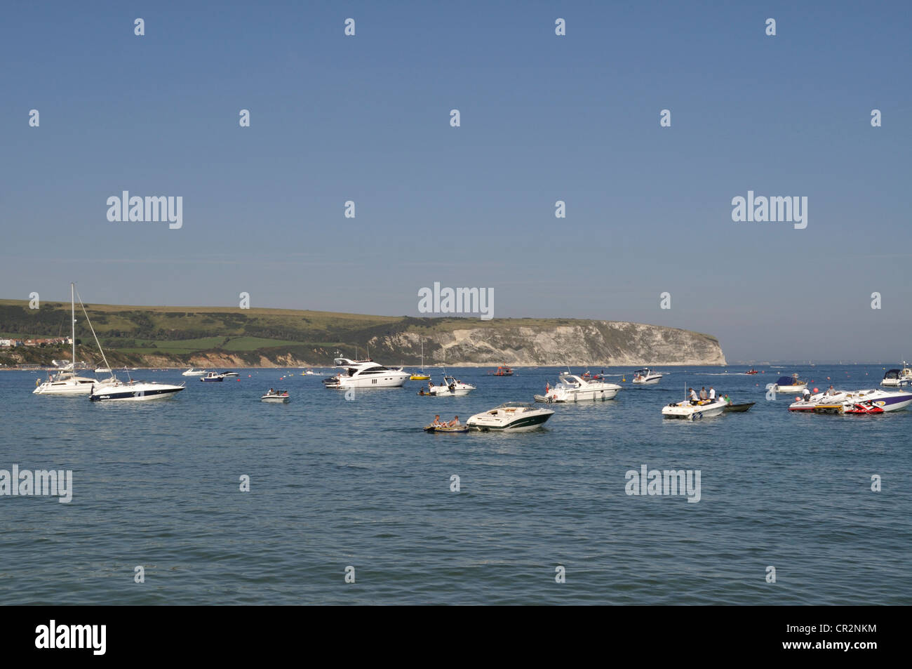 Boats moored in the bay at Swanage, Dorset, with the chalk cliffs of Ballard Down in the background. Stock Photo
