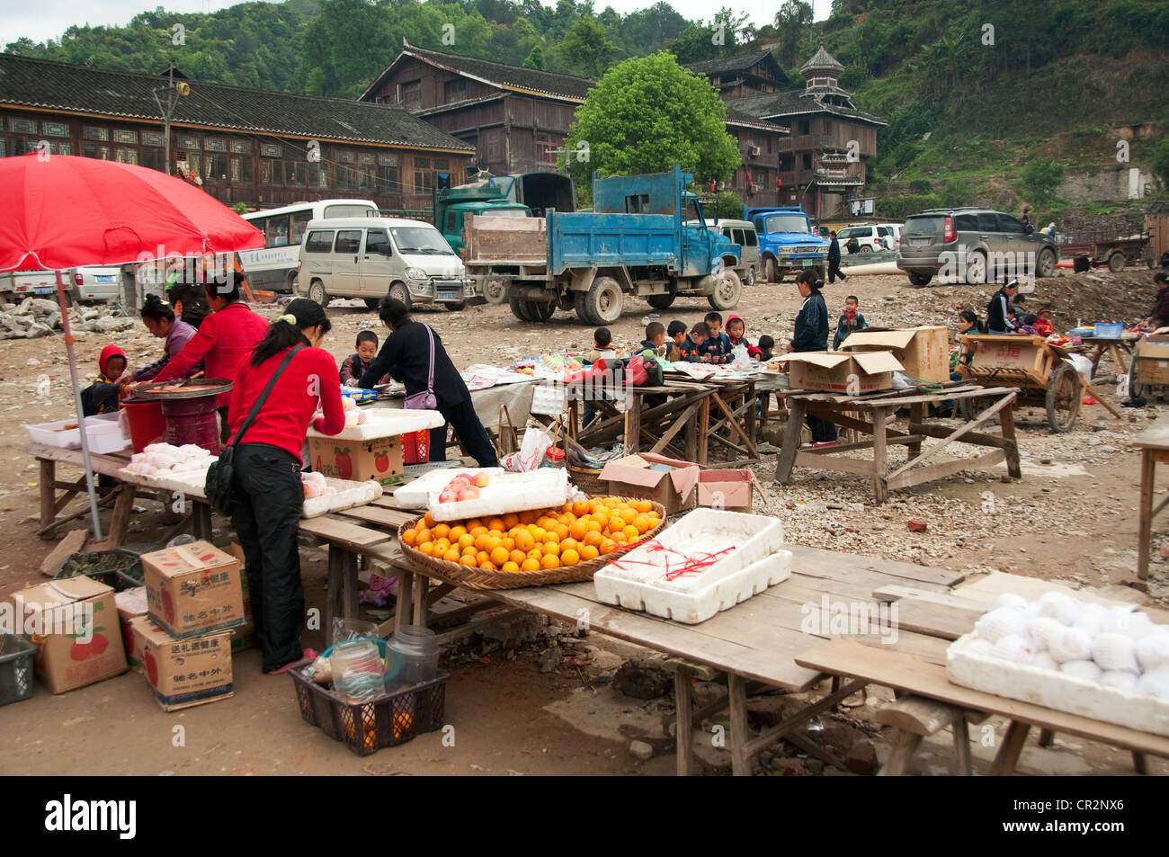 Market stall with sunshade parasol selling oranges and other fruits, Zhaoxing Dong Village, Southern China Stock Photo