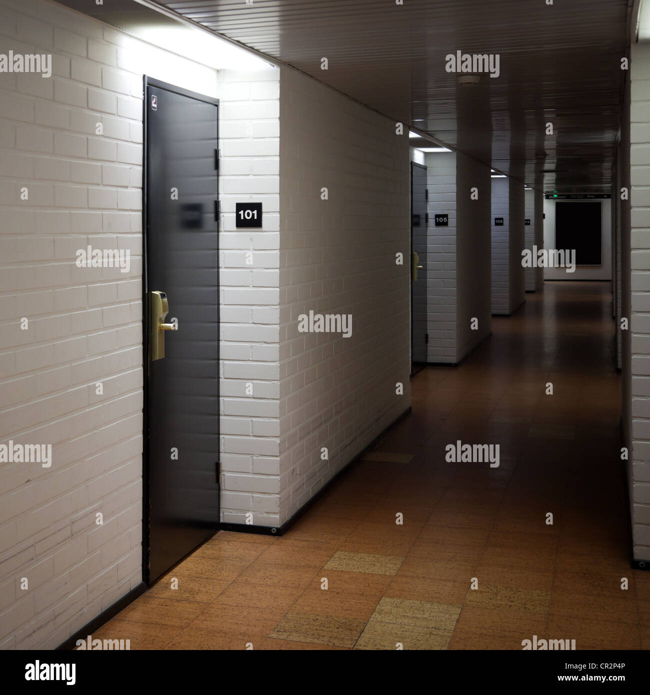 Abstract dark hotel corridor interior with doors and room numbers Stock Photo