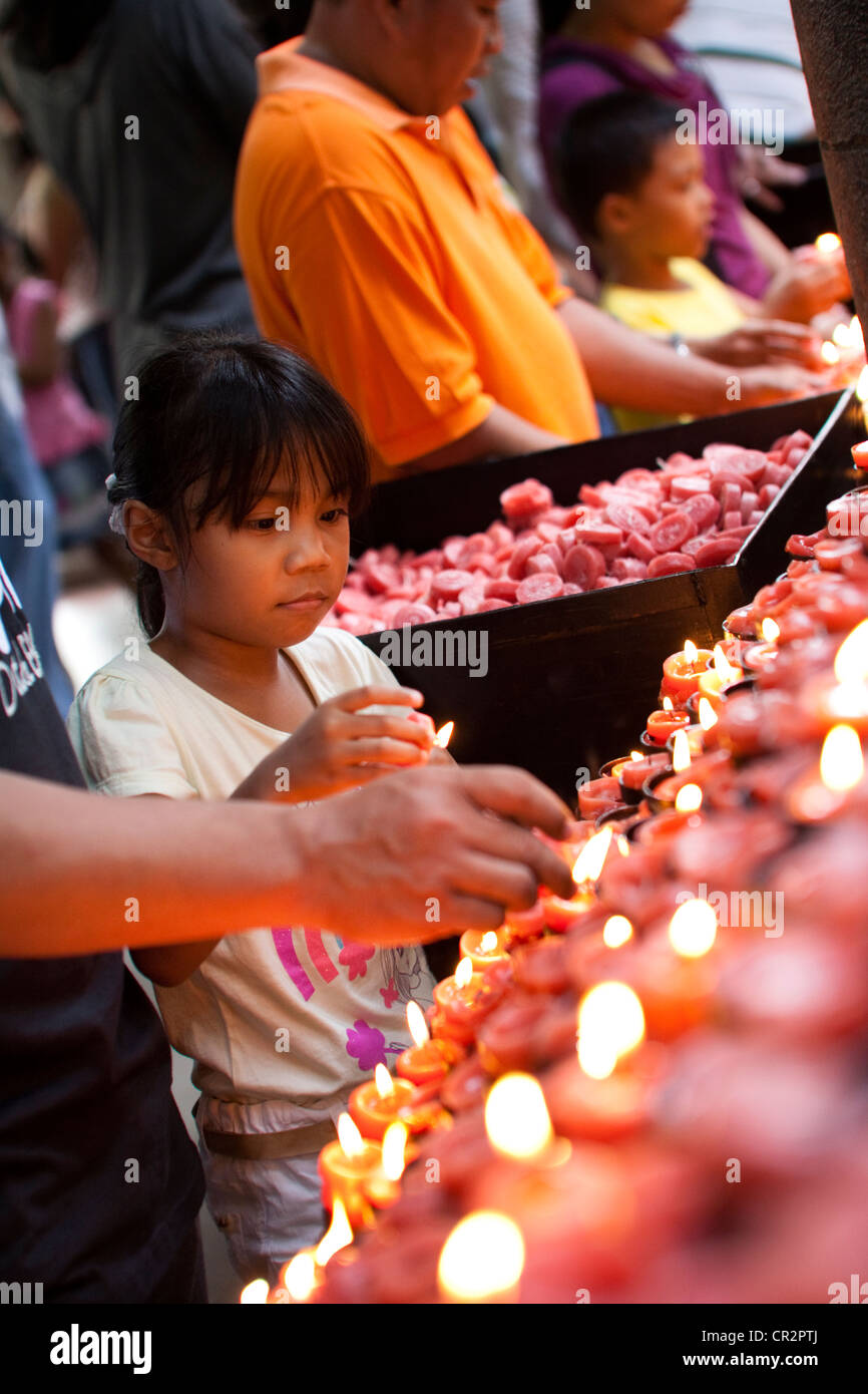 Filipinos lighting prayer candles during and after an outdoor sunday