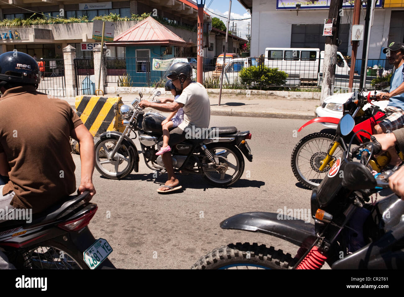 Motorcycle driver riding with his granddaughter. Lapu-Lapu City, Metro Cebu, Mactan Island, Visayas, Philippines. Stock Photo