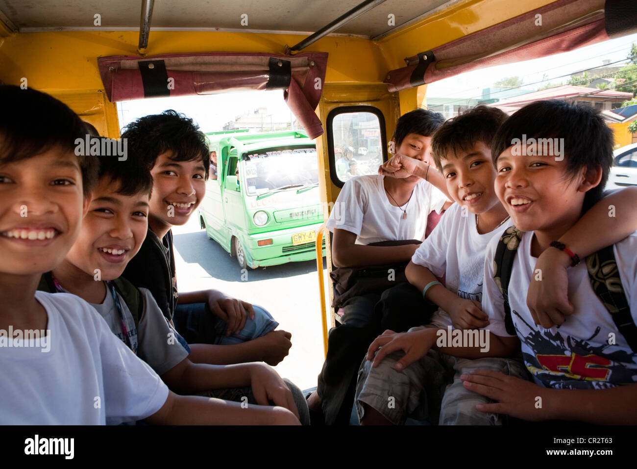 Filipino boys riding a jeepney on their way home from school. Lapu-Lapu City, Metro Cebu, Mactan Island, Visayas, Philippines. Stock Photo