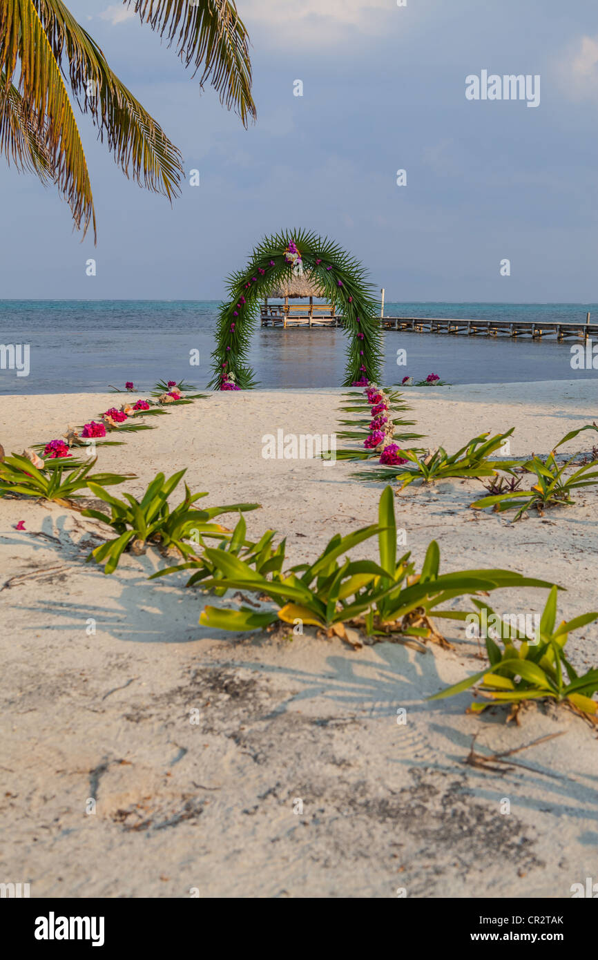 Belize Beach Wedding Arch of Palm Fronds and Pink Bougenvellia Stock Photo