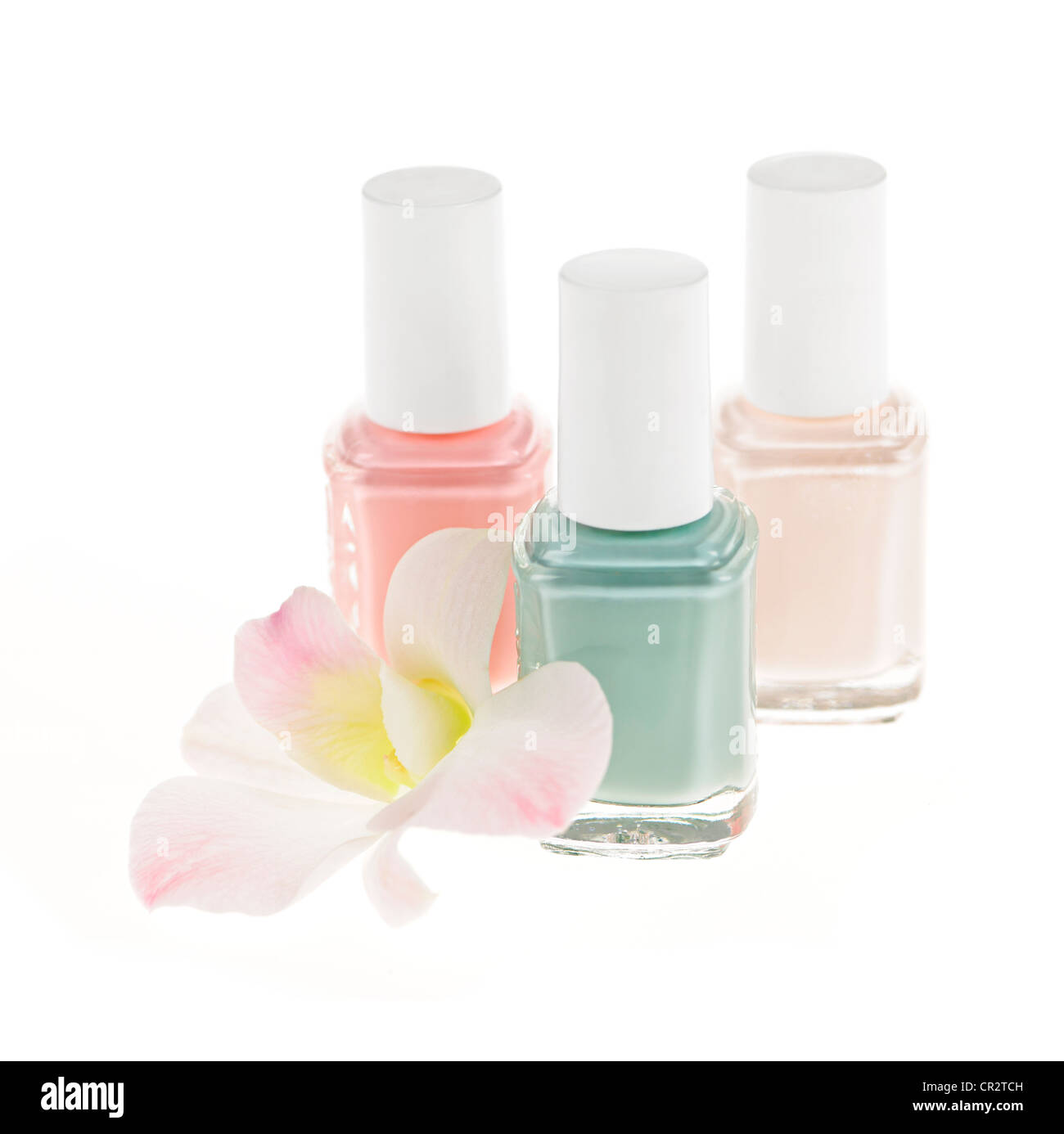 Three nail polish bottles with orchid flower on white background Stock Photo