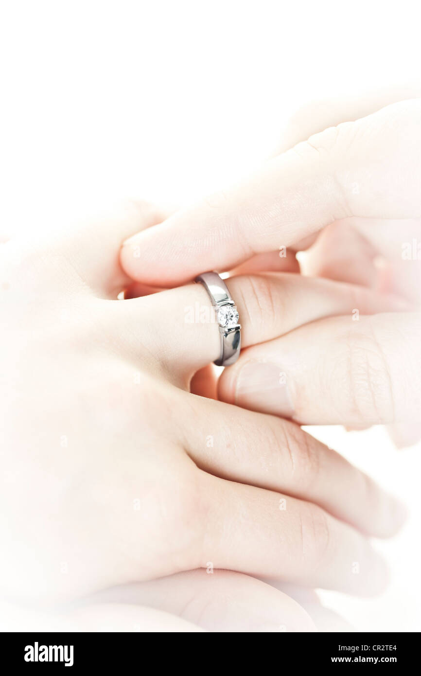 Closeup of hands placing engagement ring on finger Stock Photo Alamy