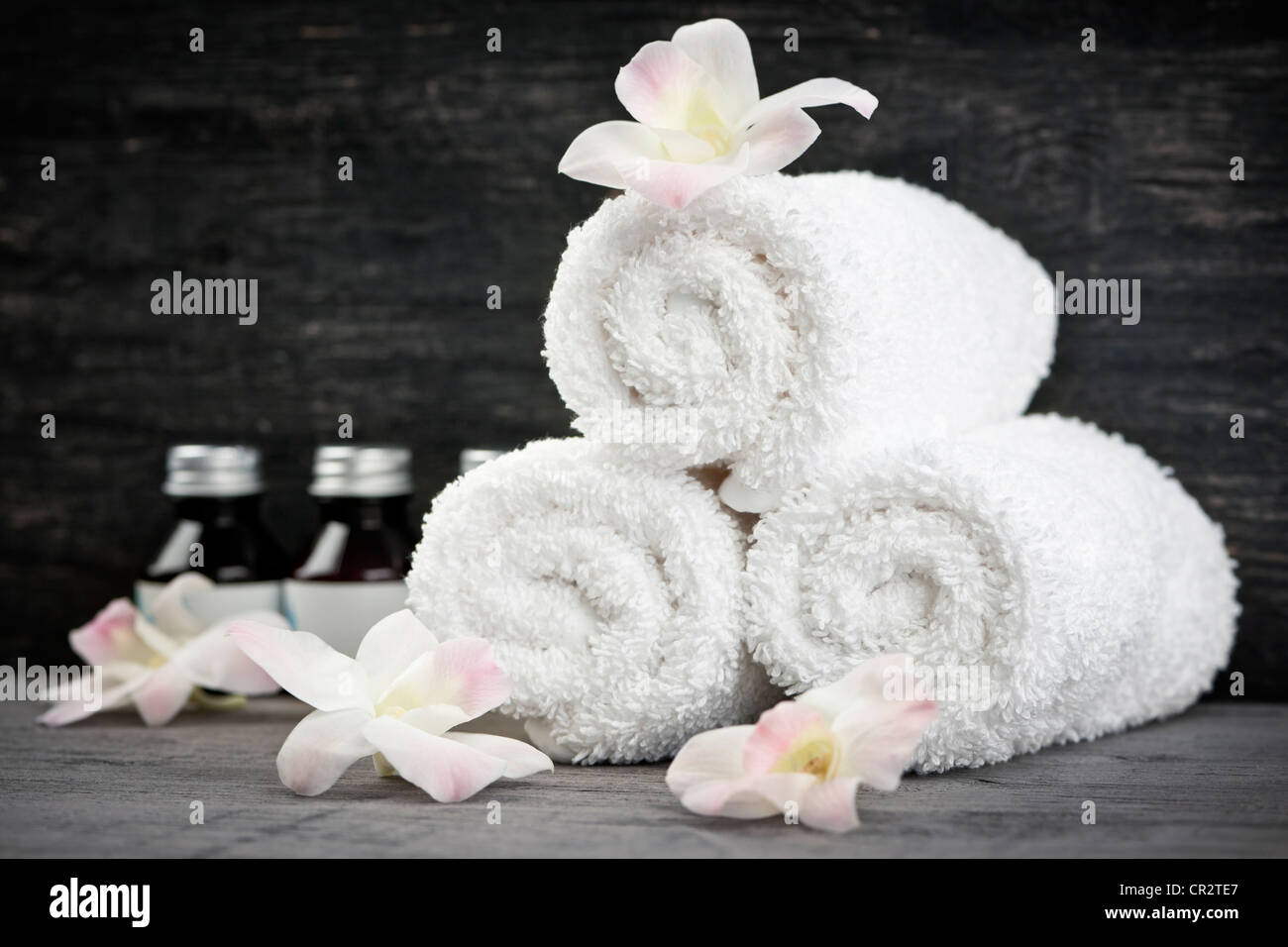 https://c8.alamy.com/comp/CR2TE7/white-rolled-up-towels-with-body-care-products-at-spa-CR2TE7.jpg