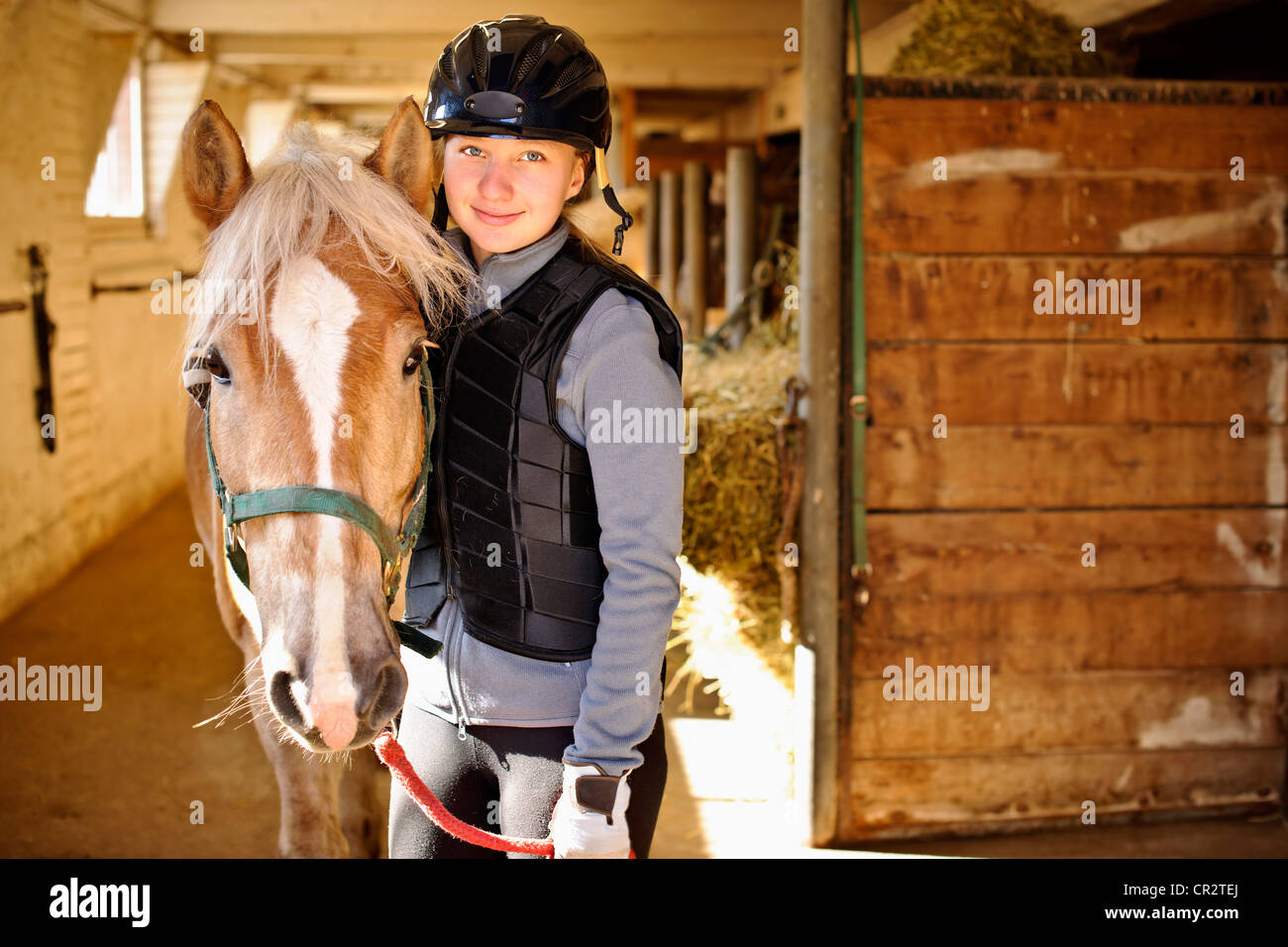 Portrait of teenage girl with horse in stable Stock Photo