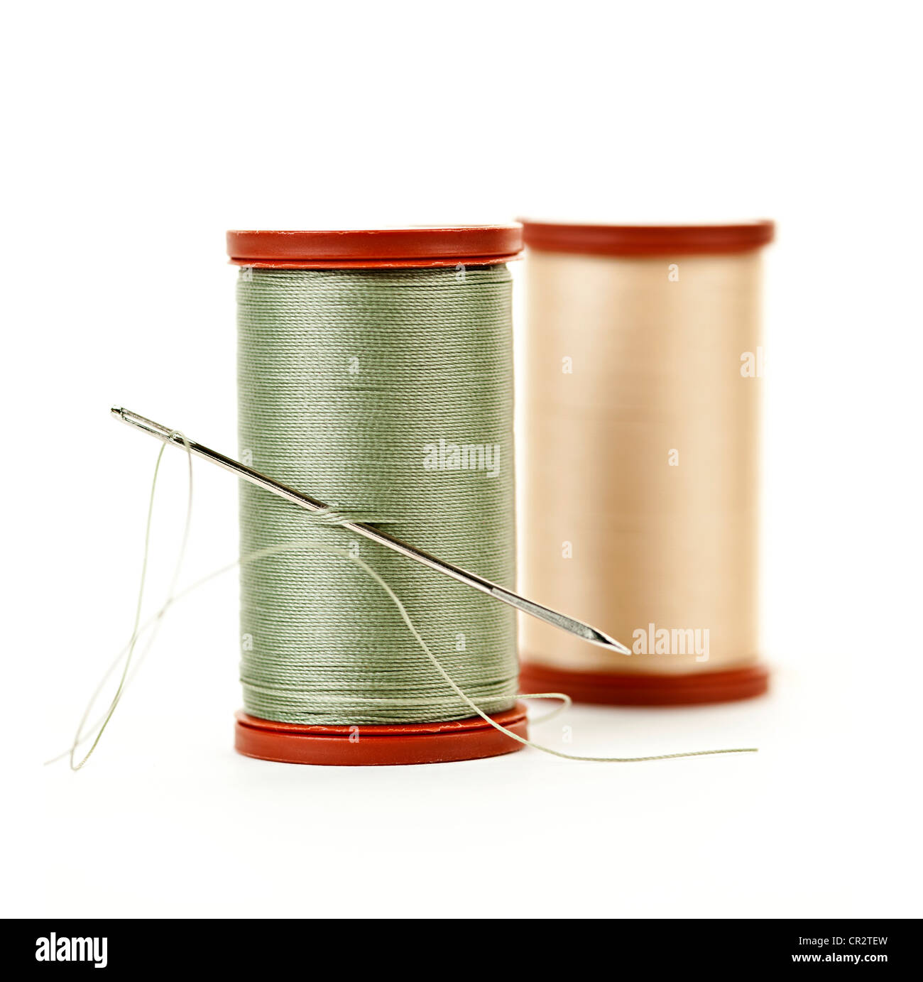 Spool of thread with needle isolated on white background. Sewing