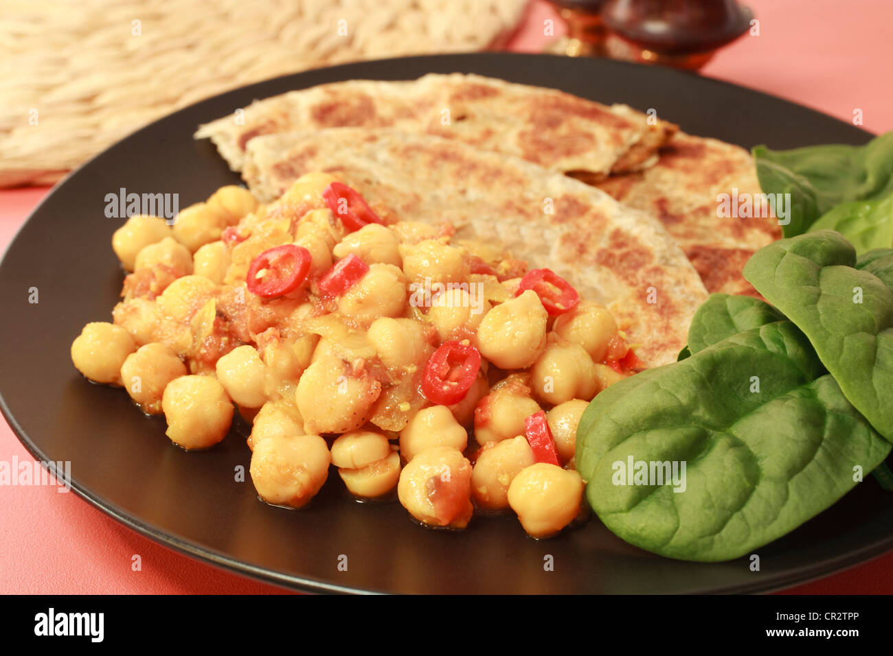 Popular Indian vegetarian snack food, channa masala or chickpea curry, on a plate with Indian roti. Stock Photo