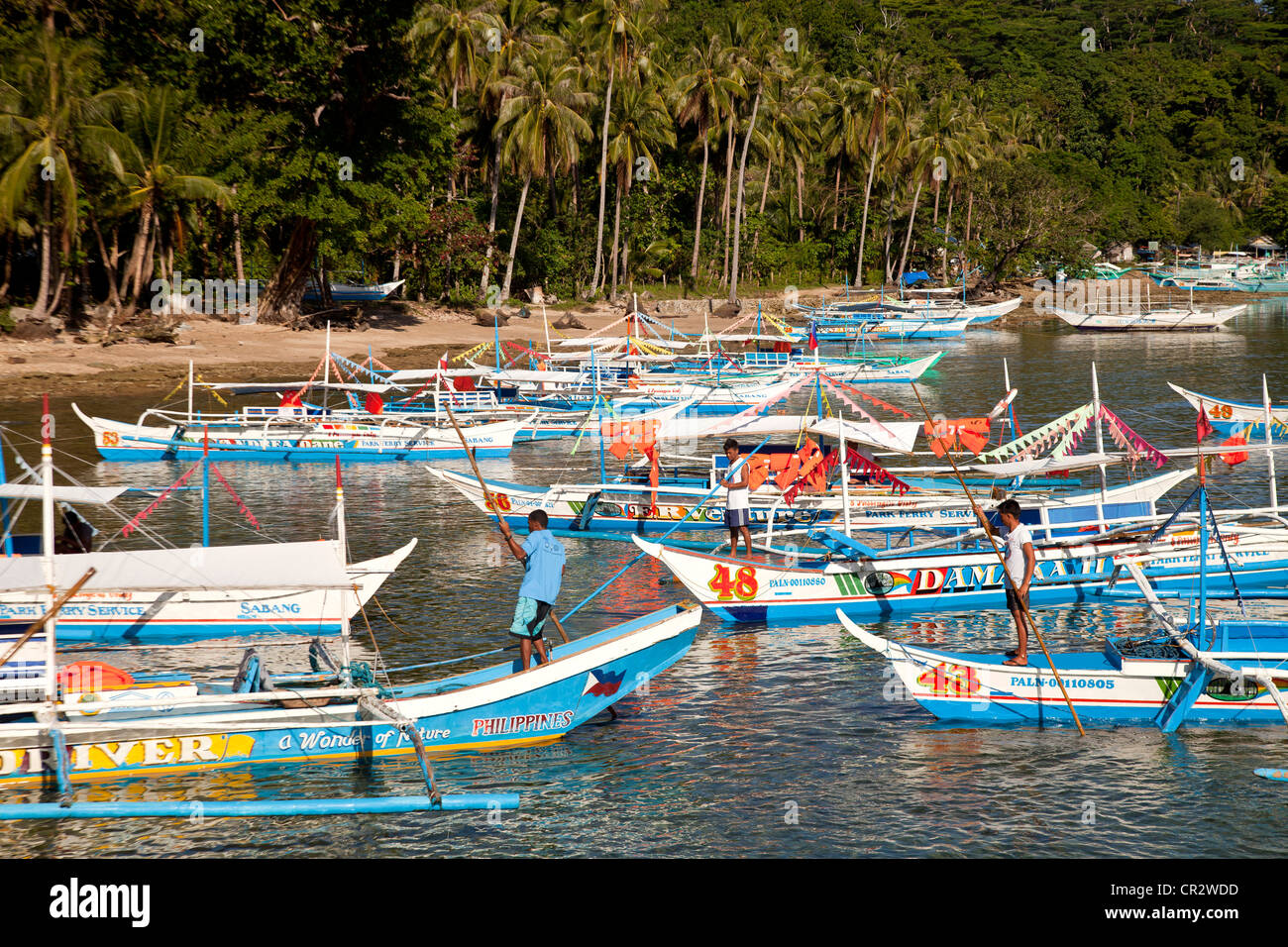 typical outrigger boats waiting to bring tourists to the underground river of Sabang, Palawan, Philippines, Asia Stock Photo