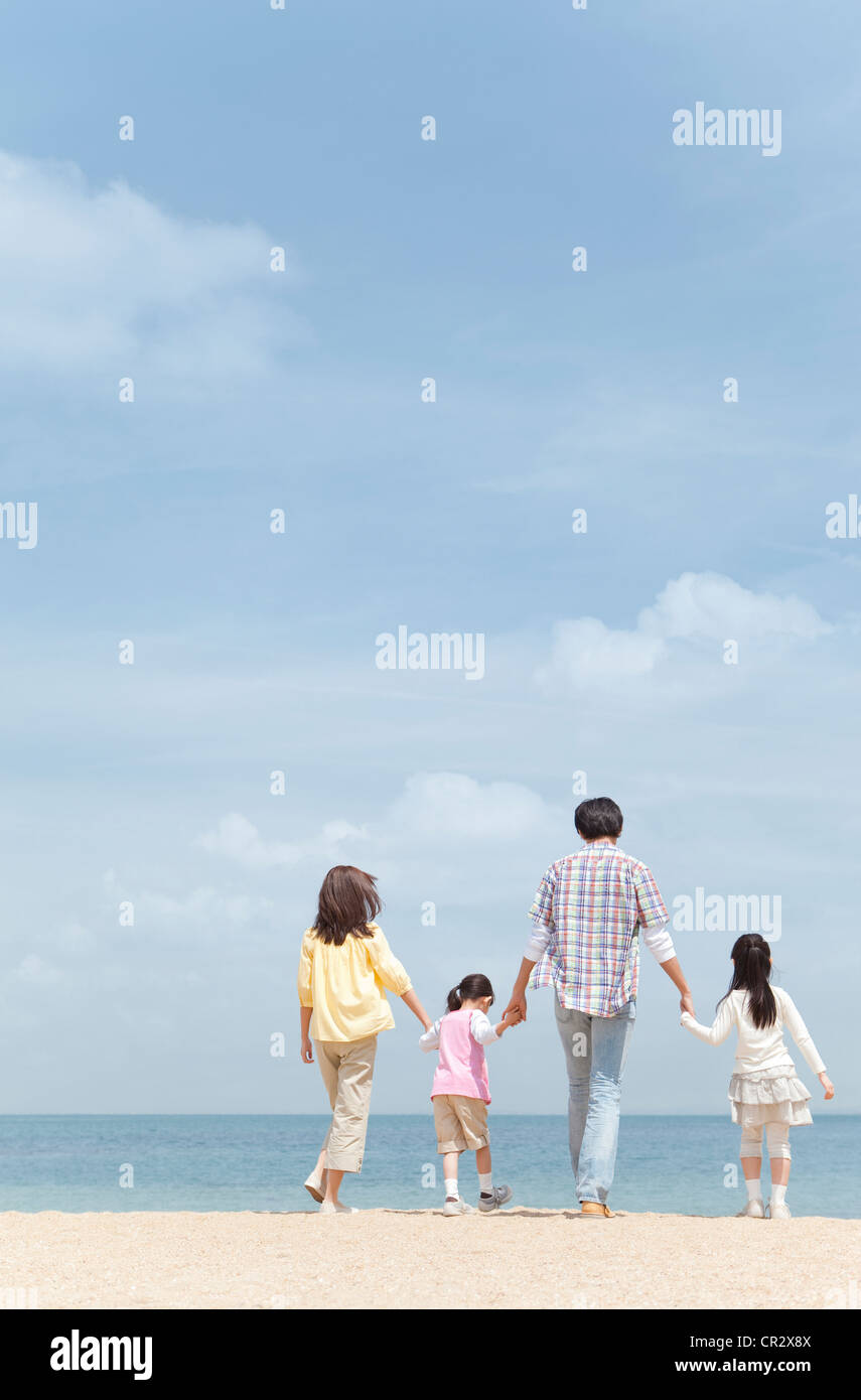 Family of Four Walking on Beach Hand In Hand Stock Photo - Alamy