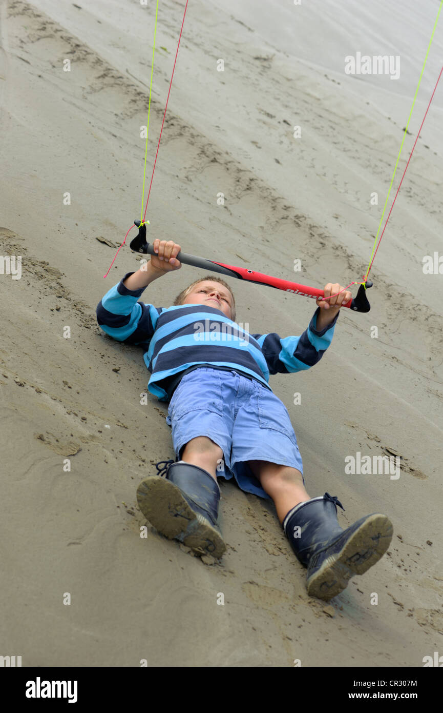 Boy flying a towing kite on the Atlantic beach, Finistere, Bretagne, Britanny, France, Europe, PublicGround Stock Photo