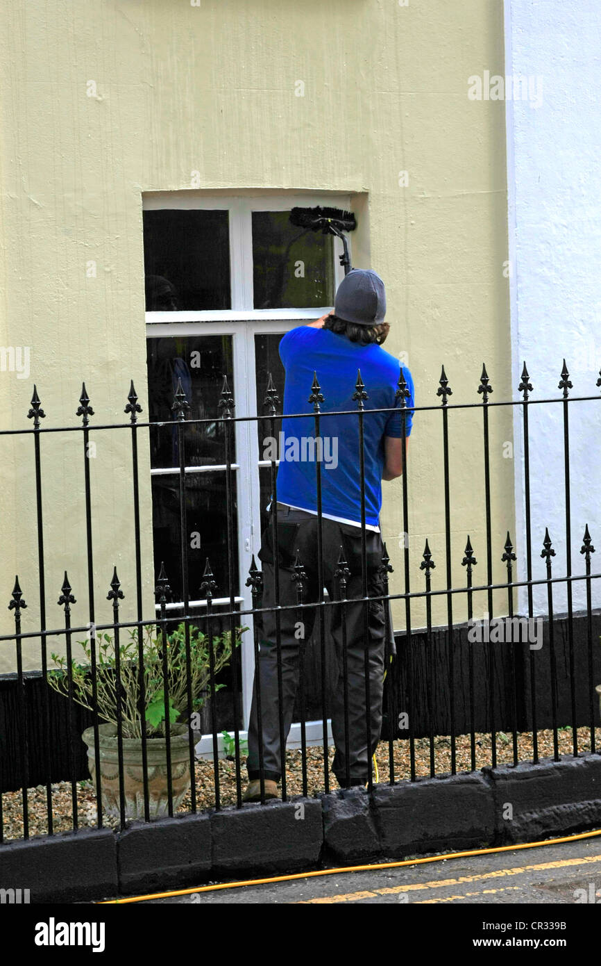 A window cleaner using the new extender pole to clean windows instead
