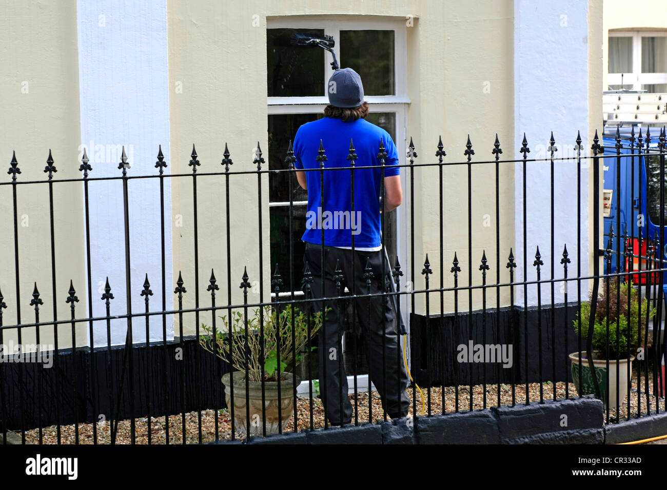 A window cleaner using the new extender pole to clean windows instead of ladders and steps Stock