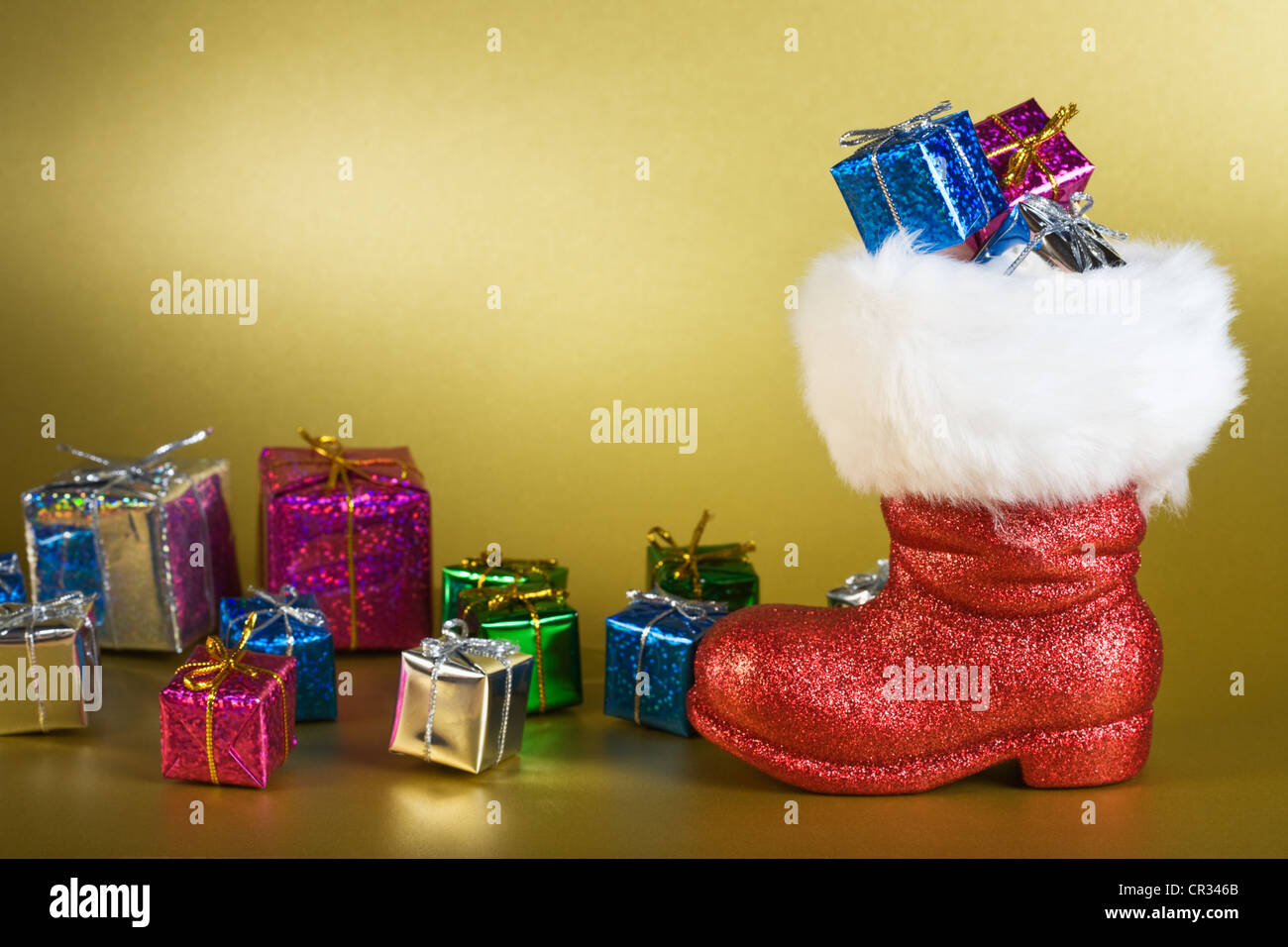 Red Santa boot and gifts on gold background Stock Photo - Alamy