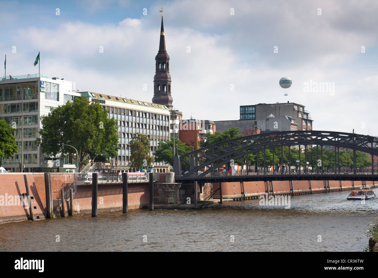 View from the Hamburg Speicherstadt historic warehouse district over the inland port and the tower of St. Catherine's Church Stock Photo