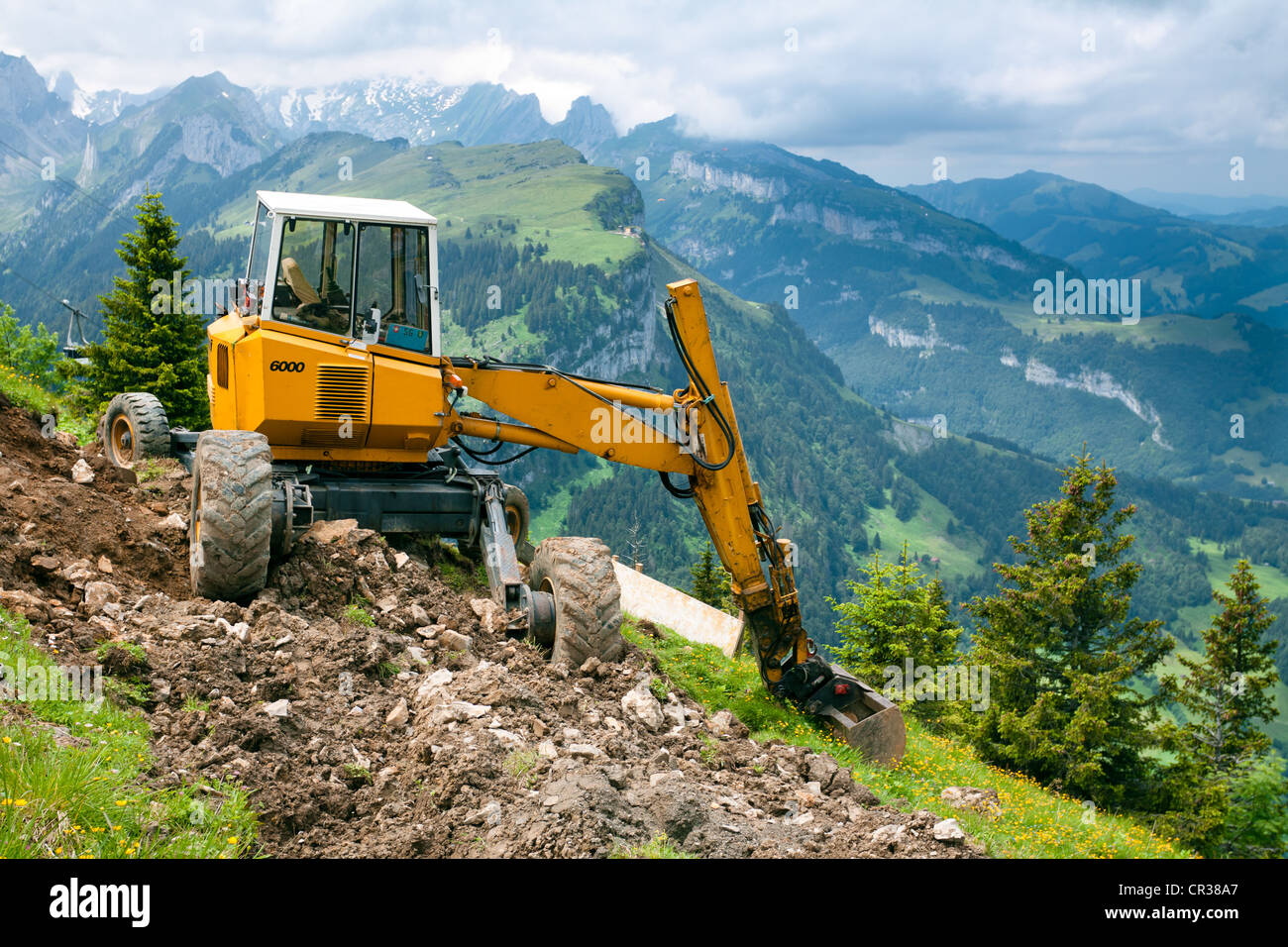 Walking excavator below the summit of Mt Hoher Kasten, 1795m, views towards Alp Sigel, Bruelisau, Appenzell Innerrhoden or Inner Stock Photo