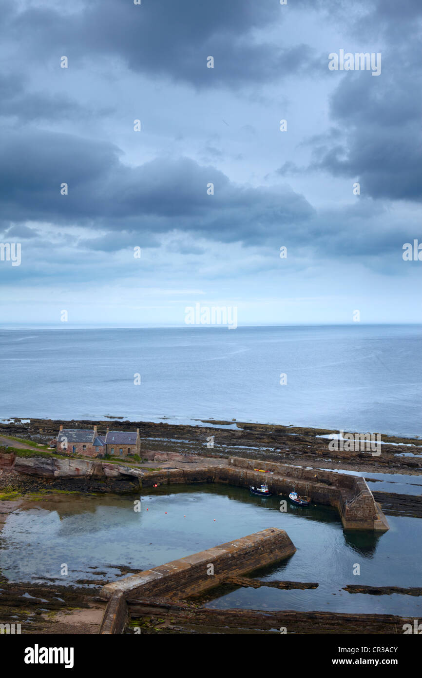 A moody spring afternoon overlooking the small harbour at Cove, Berwickshire, Scotland Stock