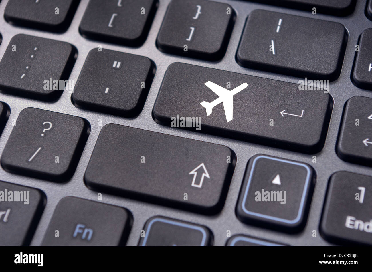 a plane sign on keyboard, to illustrate online booking or purchase of plane ticket or business travel concepts. Stock Photo