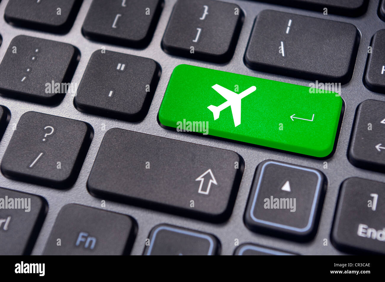 a plane sign on keyboard, to illustrate online booking or purchase of plane ticket or business travel concepts. Stock Photo