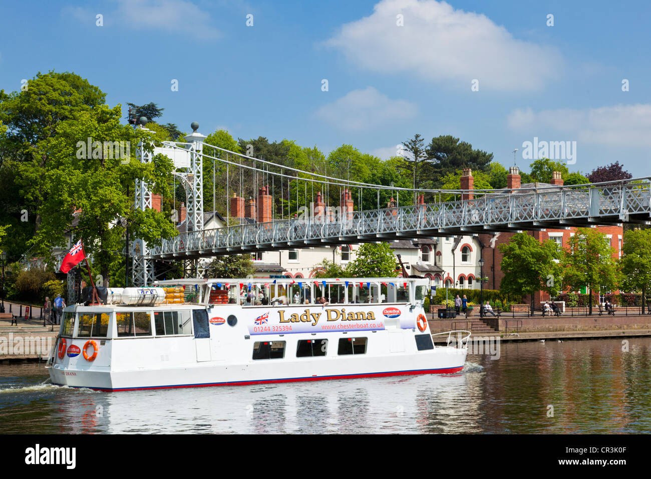 River cruise boat going under the Queen's Park suspension bridge over the River Dee Chester Cheshire England UK GB EU Europe Stock Photo