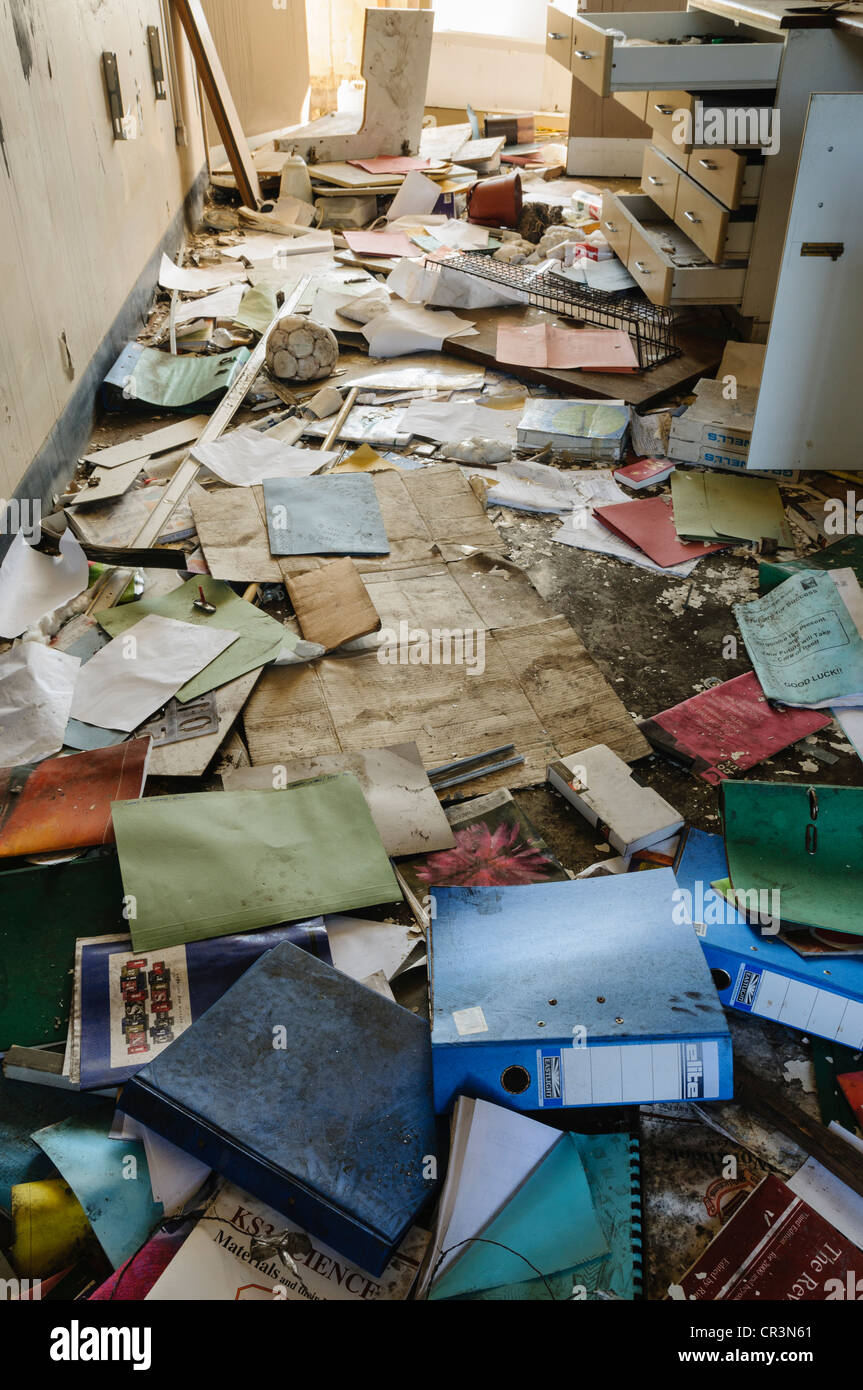 Books and papers are strewn over the floor in an abandoned school Stock Photo