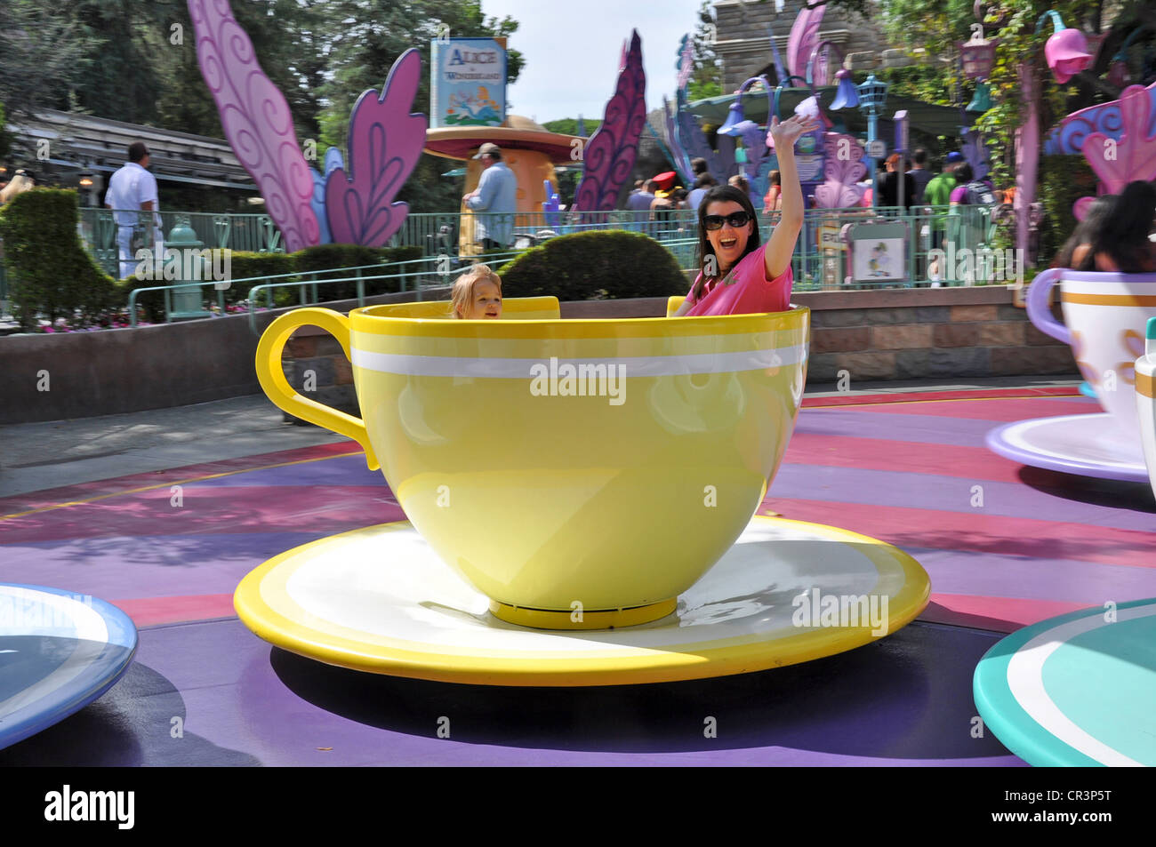 Families having fun waving while on Disneyland's Tea Cups and Saucers