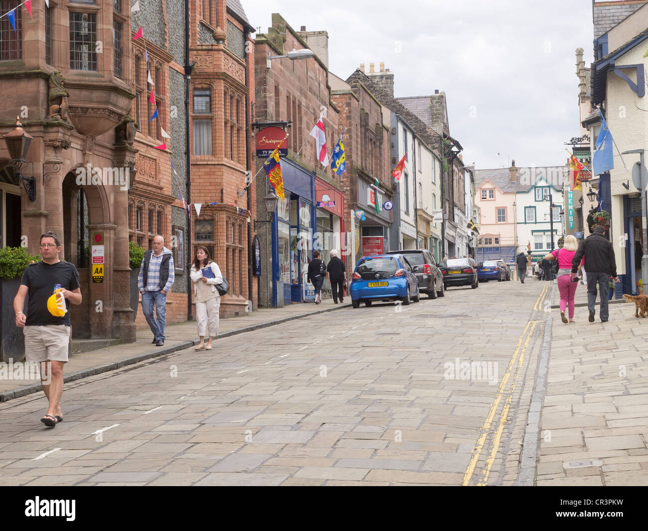 Tourists stroll up the High Street towards Lancaster Square in historic Conwy town centre North Wales Stock Photo