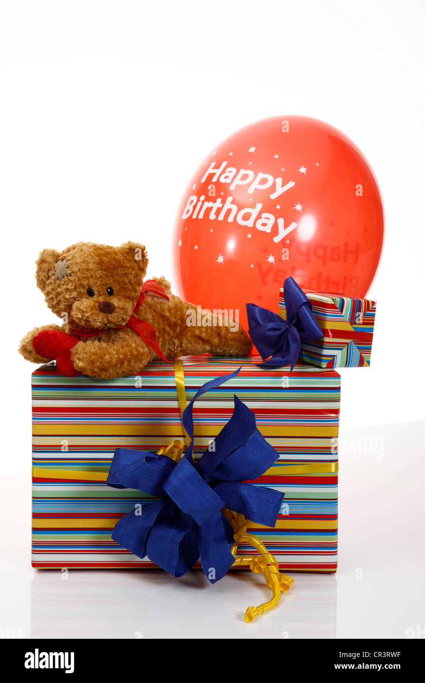 Gift with a blue ribbon, a teddy bear and a balloon, lettering Happy Birthday Stock Photo