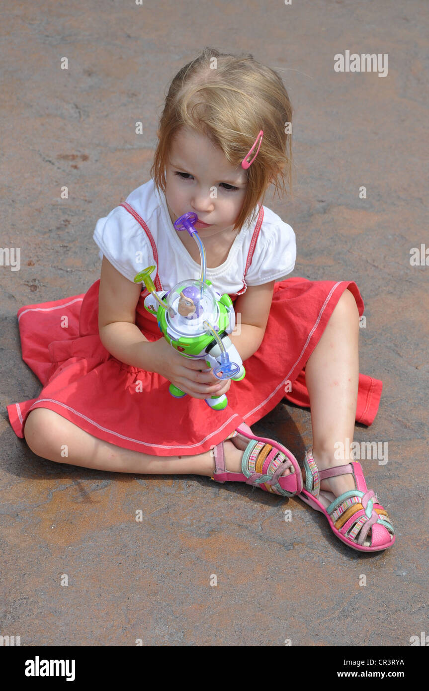 Little girl plays with Buzz Lightyear, character from 'Toy Story' at Disneyland, Anaheim, California Stock Photo