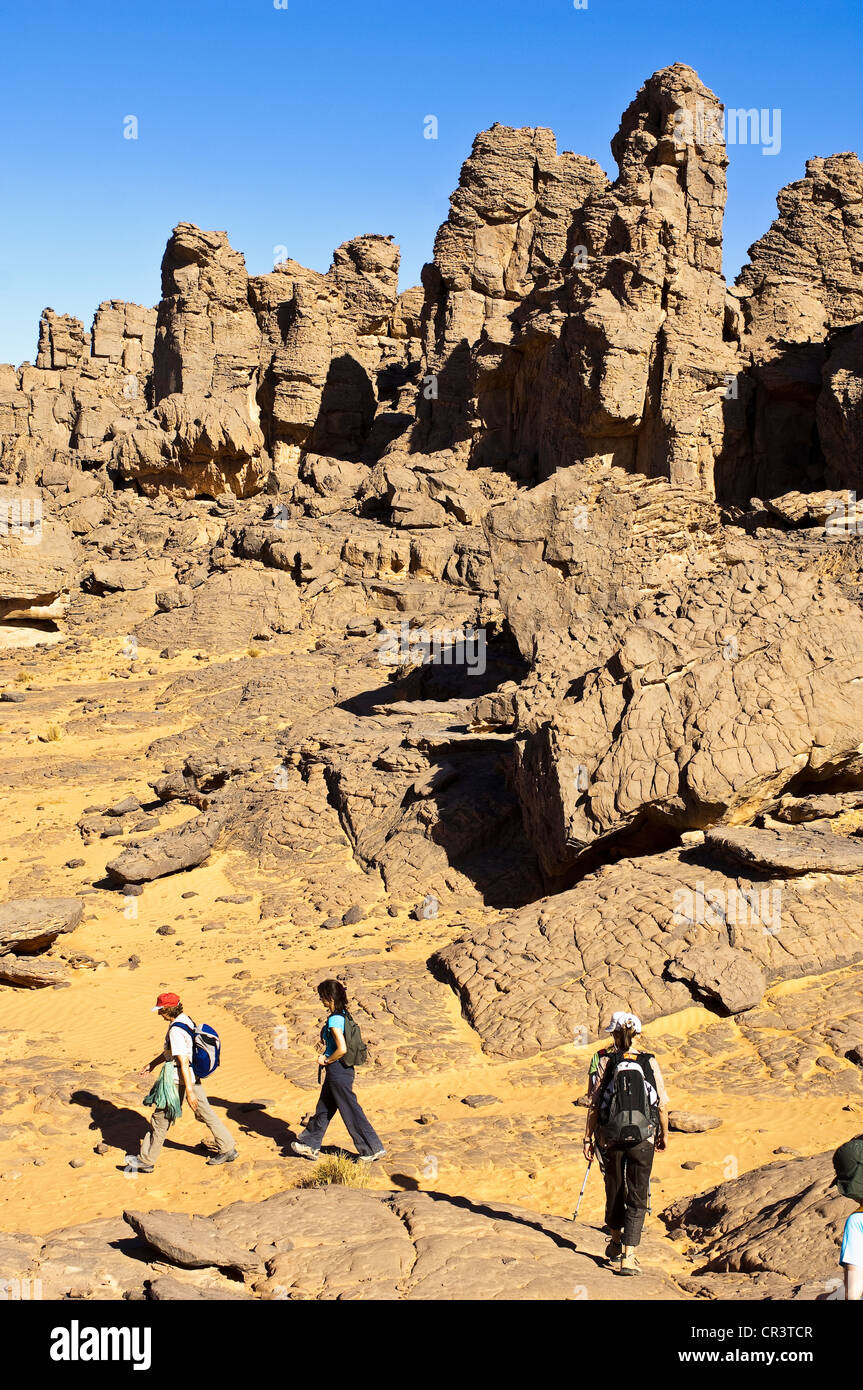 Algeria, Sahara near Djanet, Tassili N' Ajjer Massif, national park UNESCO World Heritage, hikers and volcanic rock formation Stock Photo