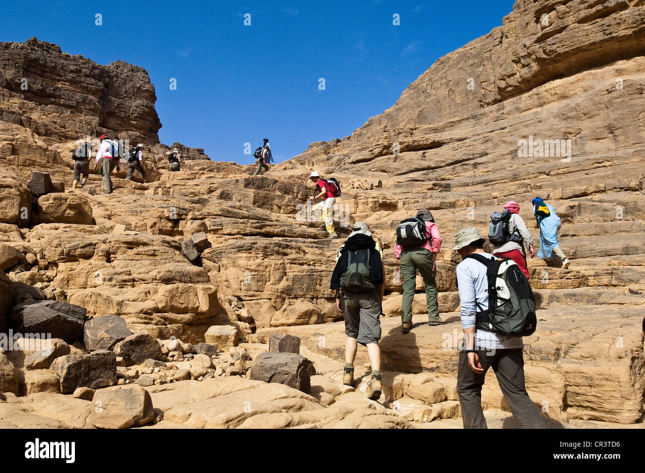 Algeria, Sahara near Djanet, Tassili N' Ajjer Massif, national park UNESCO World Heritage, hikers in sandstone rocks, between Stock Photo