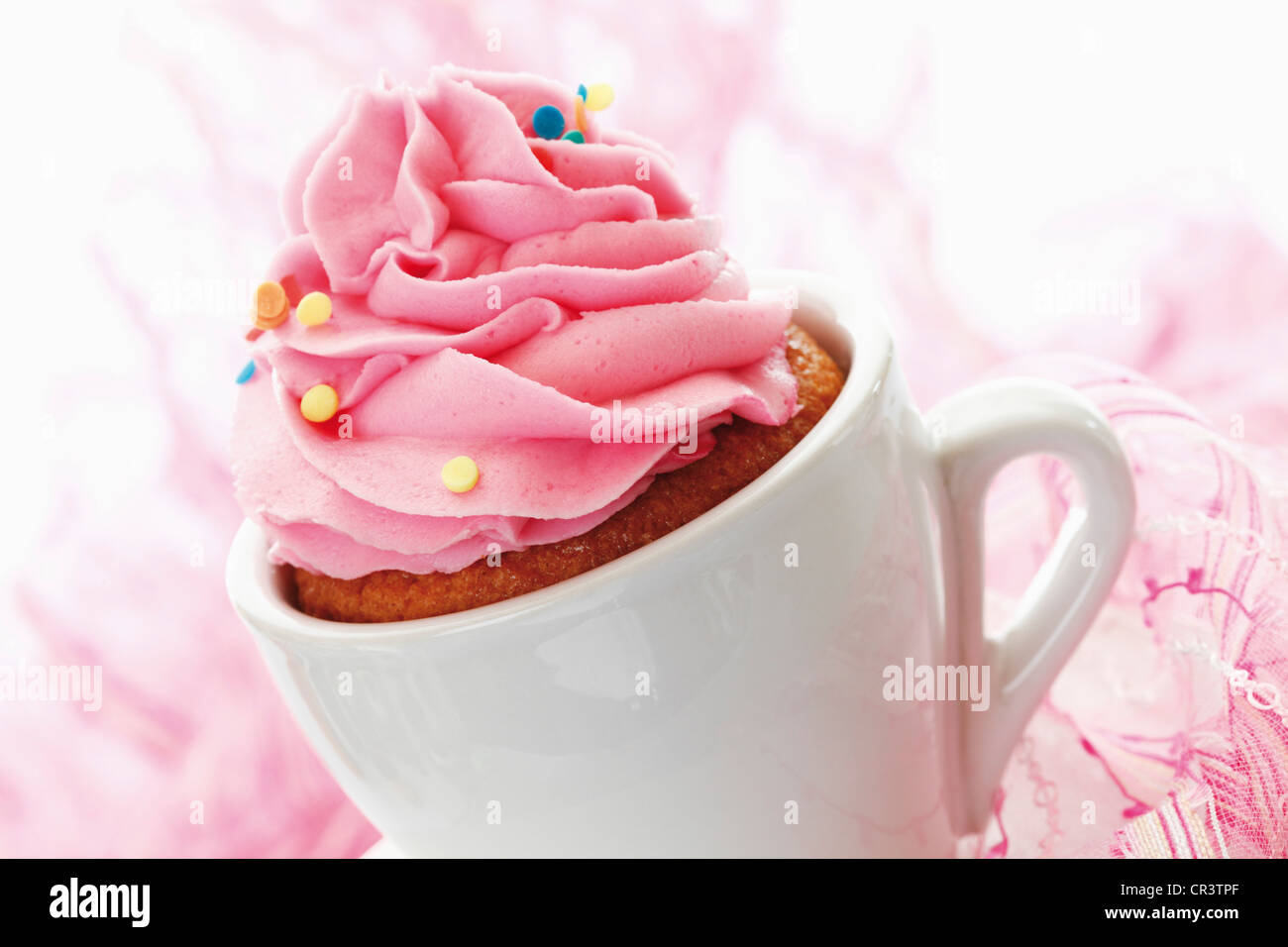 Cupcake with strawberry butter cream in white coffee cup Stock Photo