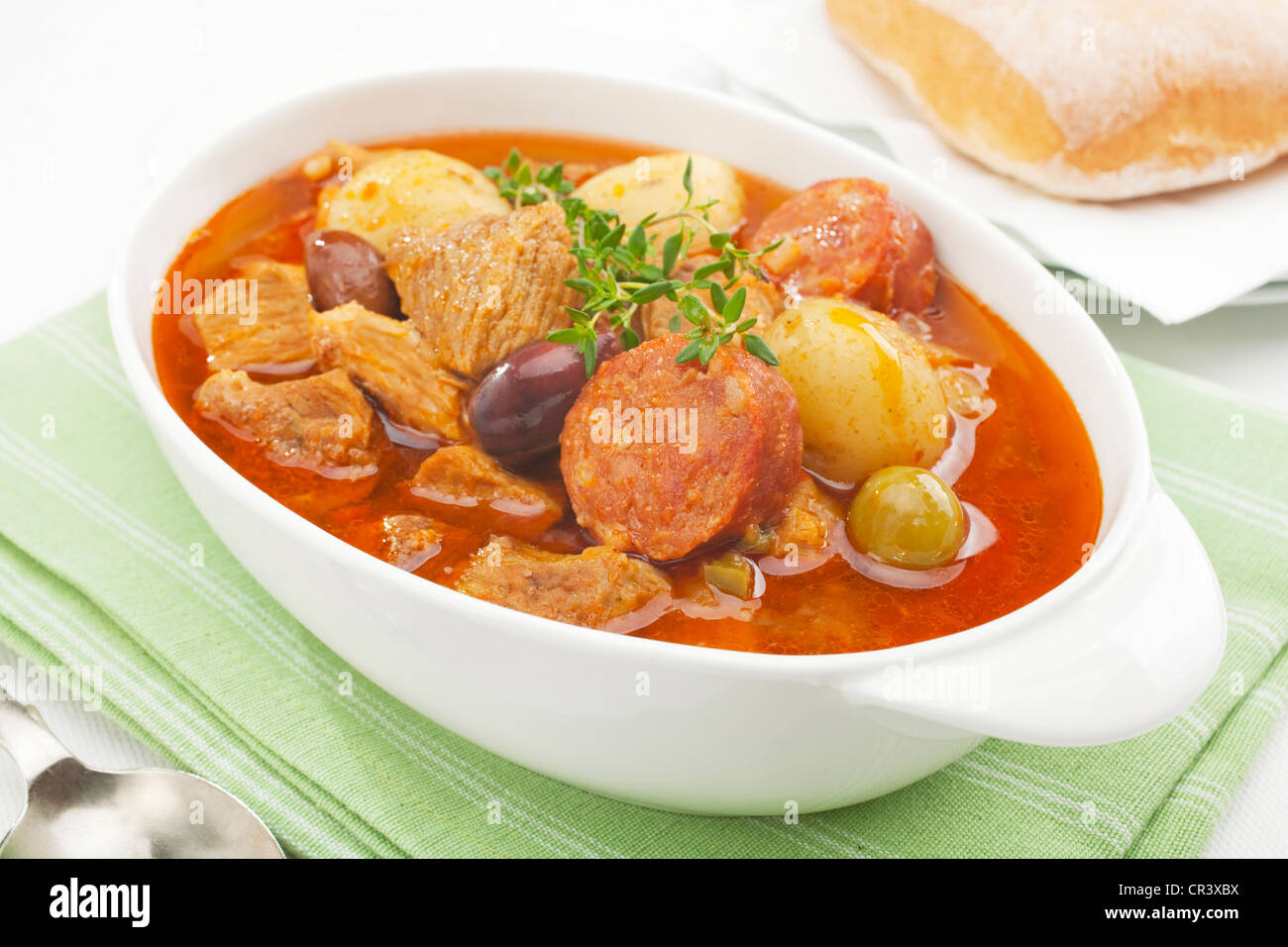 A Spanish stew, pork and chorizo casserole, with potatoes, tomatoes, peppers, olives and white wine. Stock Photo