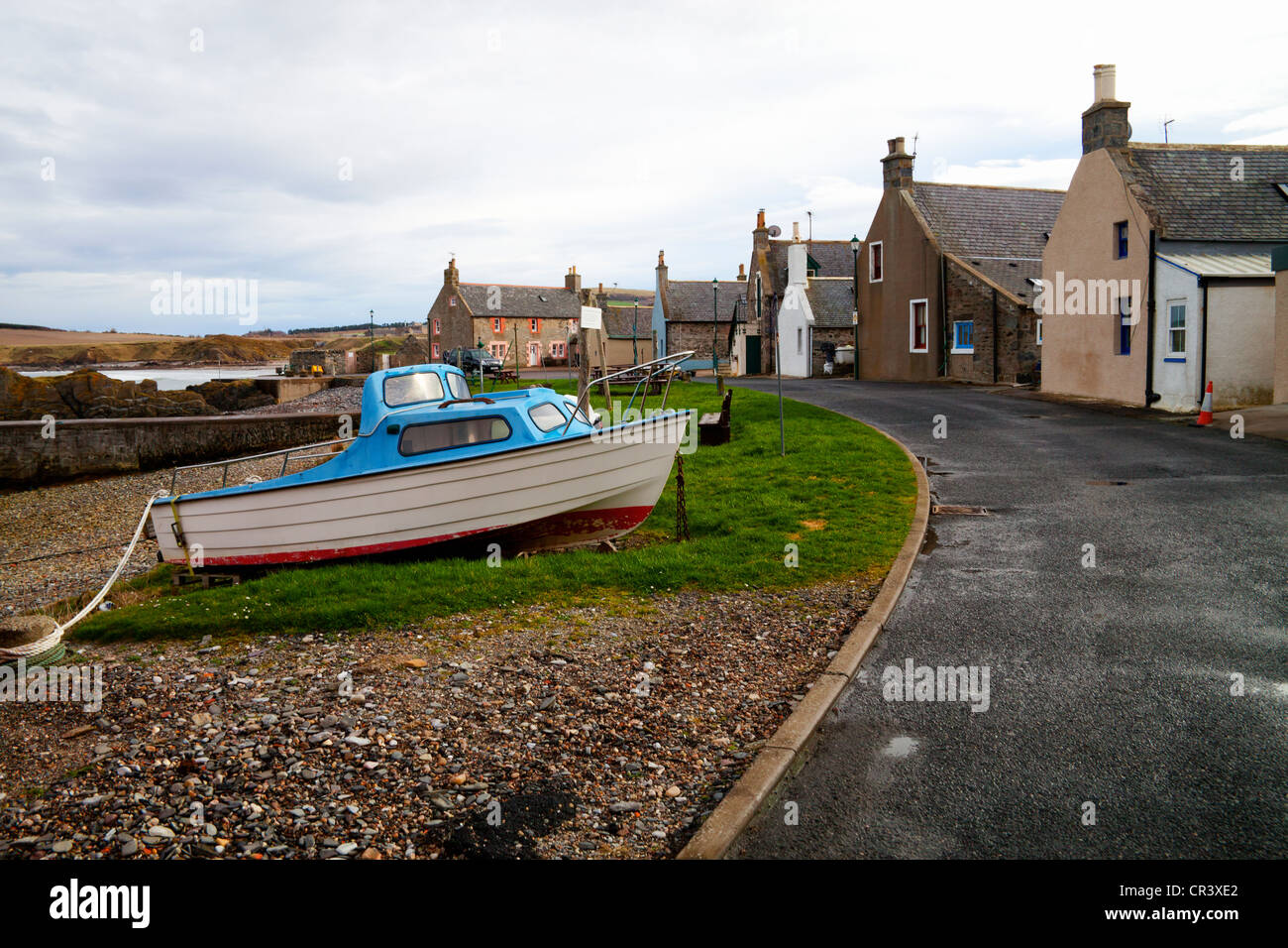 A boat moored to an old stone Bollard  in Sandend, Aberdeenshire, Scotland Stock Photo