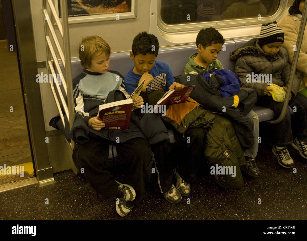 Young boys doing a little reading as they ride the New York City subway, Manhattan Stock Photo