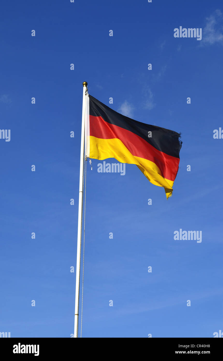 German flag flying against a blue sky with clouds, Germany, Europe Stock Photo