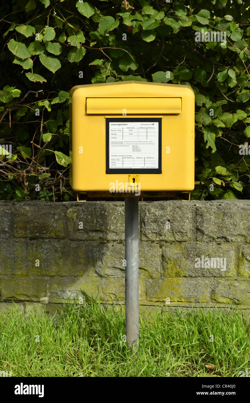Yellow mailbox of Deutsche Post, German postal service, daily collection, between Dorsten and Gelsenkirchen, Ruhr Area Stock Photo