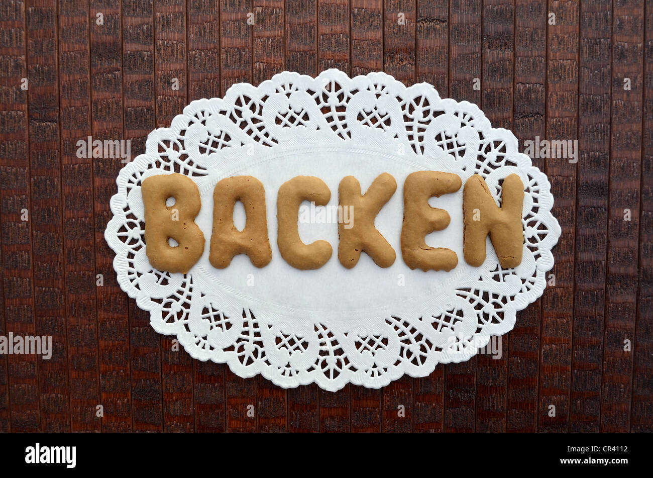 Backen, German for baking, written with alphabet biscuits on a paper doily Stock Photo