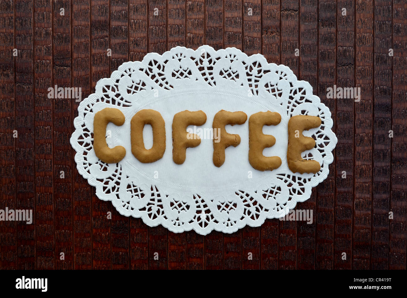 Coffee, written with alphabet biscuits on a paper doily Stock Photo