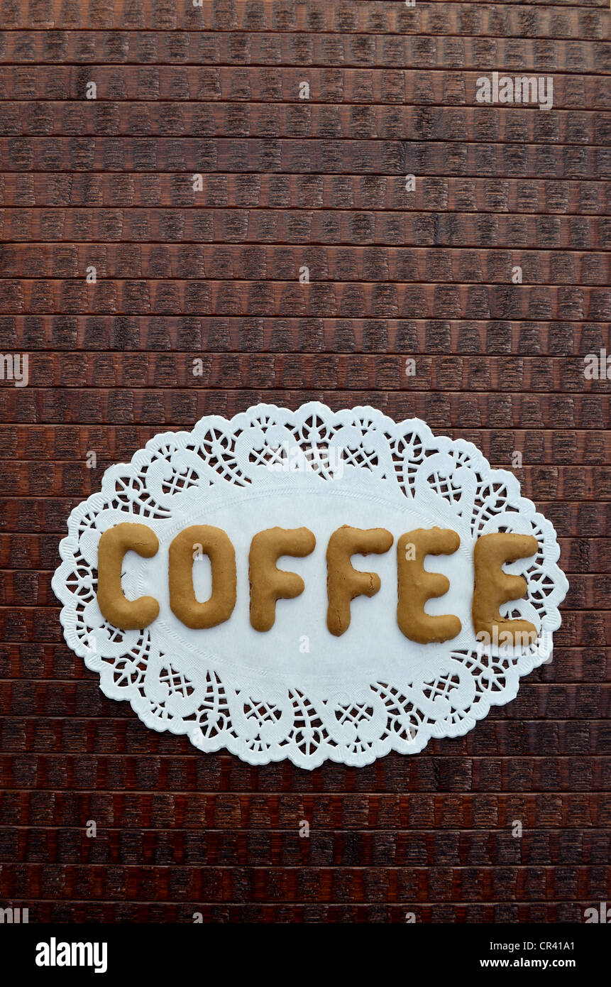 Coffee, written with alphabet biscuits on a paper doily Stock Photo
