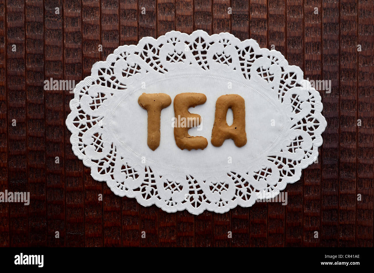 Tea, written with alphabet biscuits on a paper doily Stock Photo