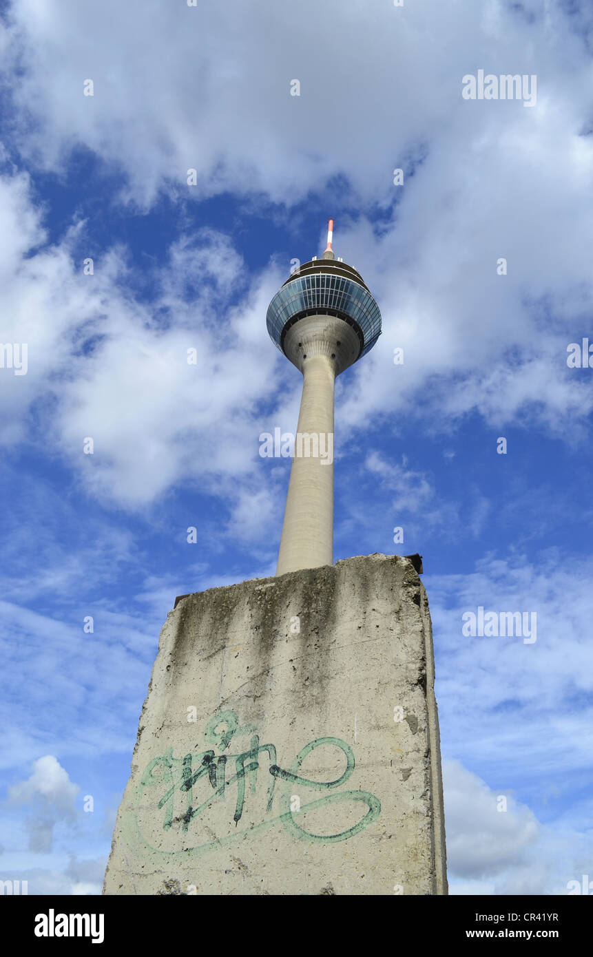 A piece of the Berlin Wall in front of the Rheinturm tower, Duesseldorf