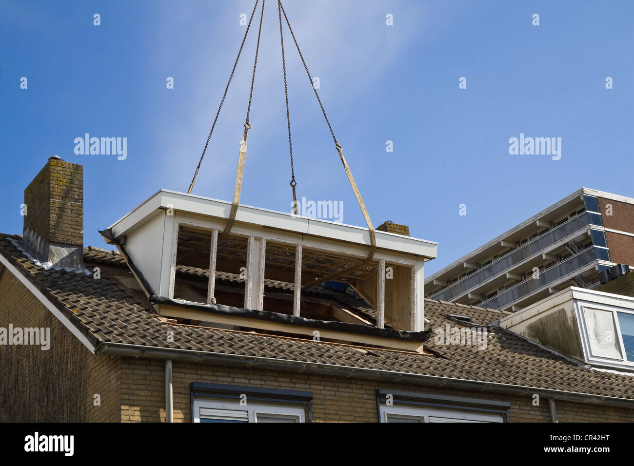 Placing the new dormer-windows on the roof. Stock Photo