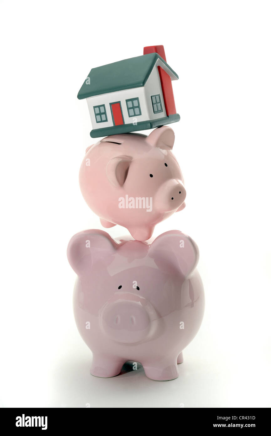 PIGGYBANKS BALANCING MODEL HOUSE RE HOUSEHOLD BUDGETS HOME BUYERS MORTGAGES PROPERTY MARKET HOUSE PRICES INCOMES SAVINGS ETC UK Stock Photo