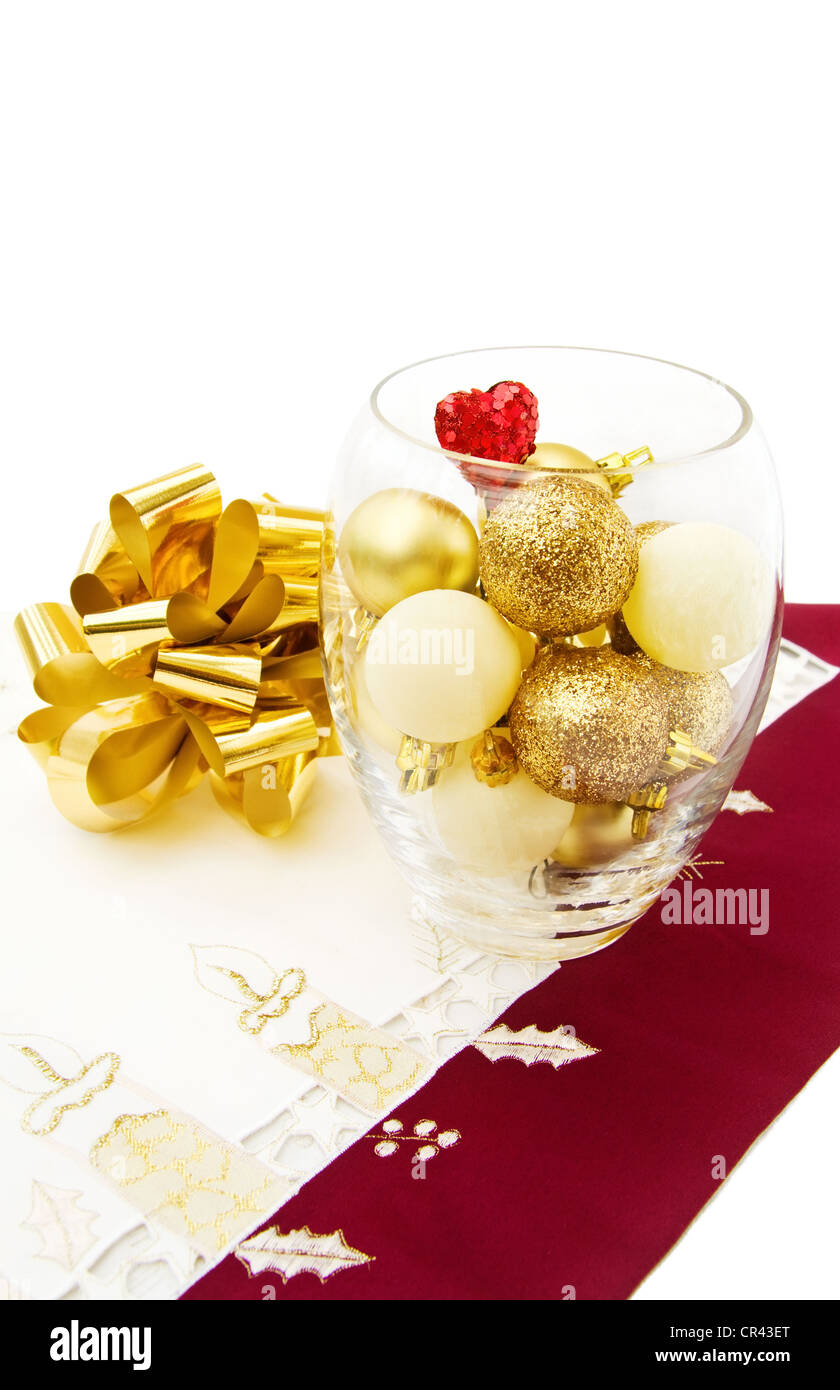 Celebrating Christmas with golden baubles, sparkling heart and festive ribbons. Isolated on white background. Stock Photo