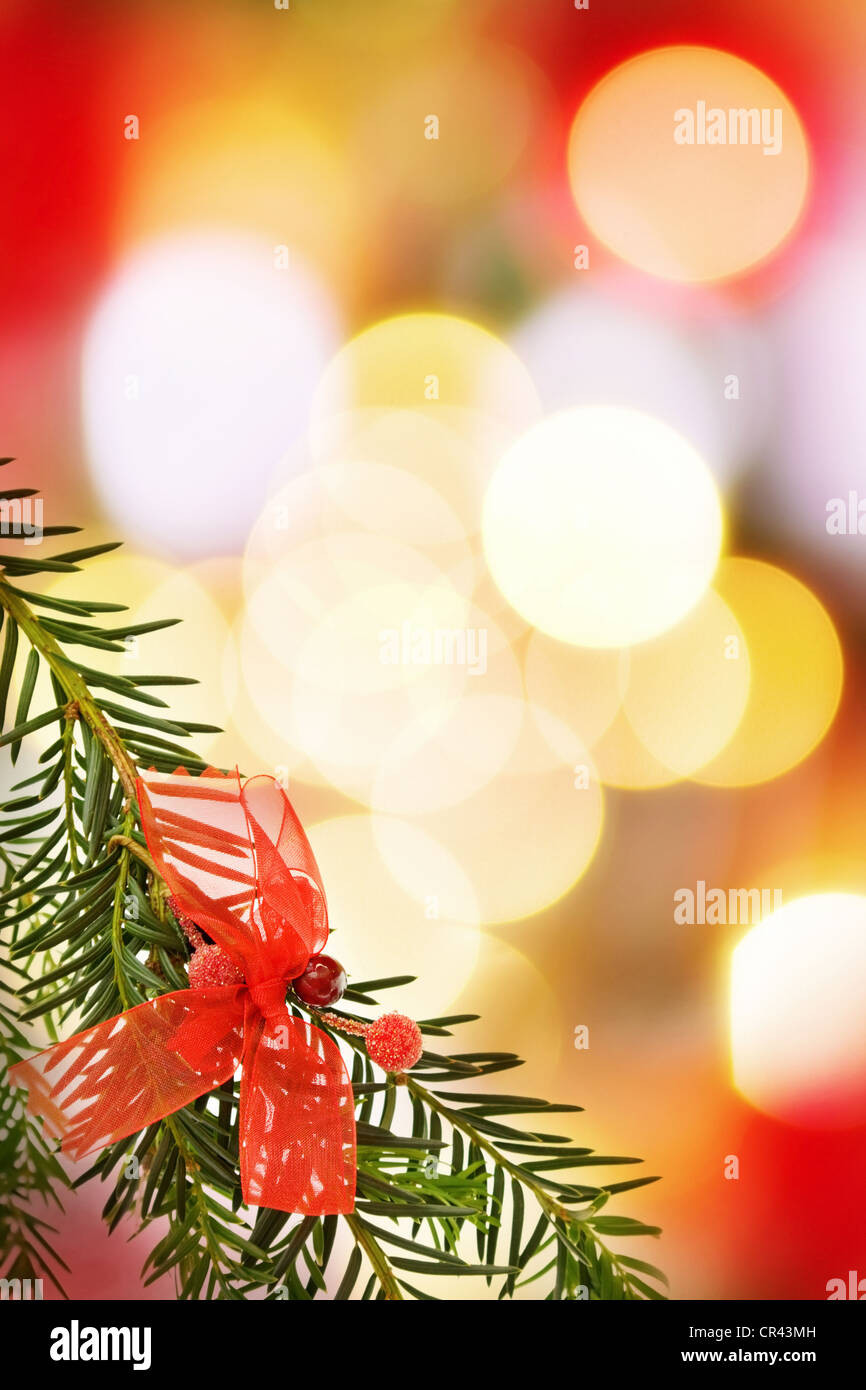 Christmas greeting card with festive border of pine tree and decoration over defocused lights. Stock Photo