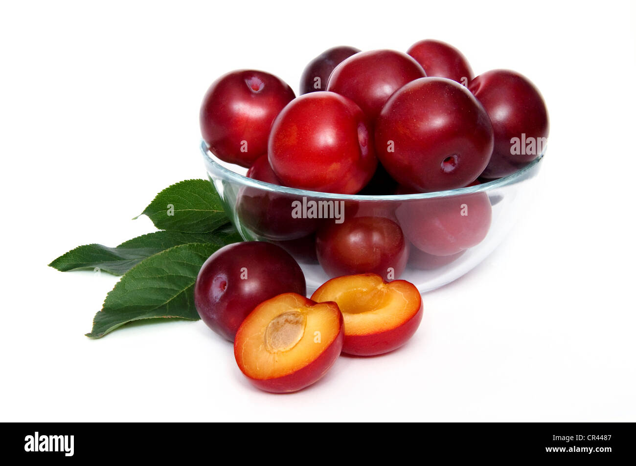 plums in a glass bowl over white background Stock Photo Alamy