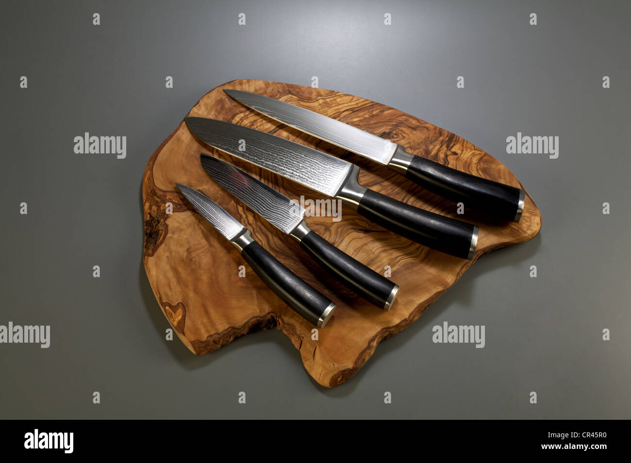 Damascus knives on olivewood board Stock Photo